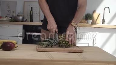 厨师在木板上切菠萝。 男人厨师手在厨房里切菠萝。 新鲜菠萝楔子