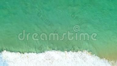 从绿色<strong>海水</strong>表面的无人机照相机俯视，海浪<strong>拍打</strong>在沙质海岸。