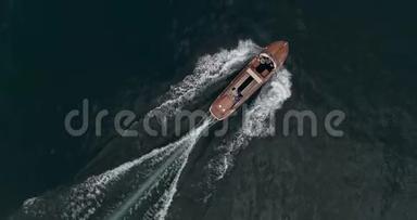 旧红木摩托艇正沿着意大利的加德纳湖航行。 空中射击。