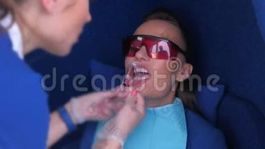 护士准备妇女LED美白牙齿安装牙科拉钩。