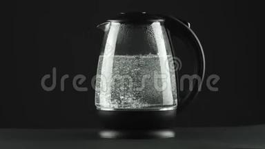 在有透明玻璃墙的电<strong>热水壶</strong>里，水沸腾了.. 黑色背景。