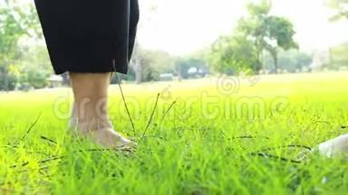 在阳光明媚的夏天，亚洲老年妇女<strong>赤脚</strong>在草地上行走，老年妇女用手杖<strong>走路</strong>
