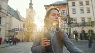 女人手里拿着一个保温杯，走在街上，看着她的手表，匆忙地在日落时分参加一个会议