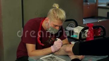 纹身师傅用纹身机为纹身店的女孩做纹身。