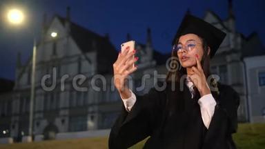 可爱的毕业生女孩用她的手机做准备。