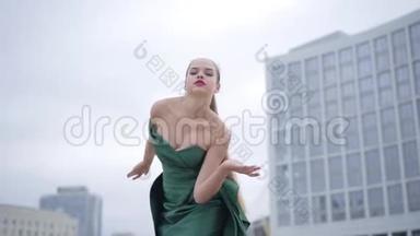 美丽漂亮的姑娘，穿着漂亮的晚礼服，在摩天大楼附近的空城广场上翩翩起舞