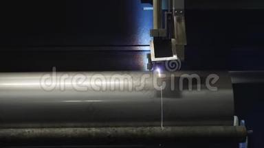 金属钢管上机器切割曲线的特写。 在生产现场工作的设备。 钢铁工业，钢铁