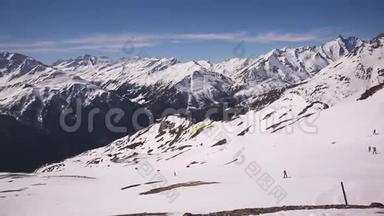 滑翔伞起飞。阿尔卑斯山雪山上带滑翔伞起飞的人