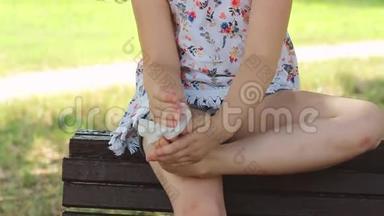 小女孩正坐在长凳上，用湿纸巾擦脚