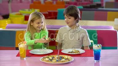 快乐的朋友在<strong>儿童娱乐</strong>中心吃巧克力披萨`。