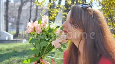 美丽迷人的年轻女子手持一<strong>大</strong>束五颜六色的鲜花在户外，靠近黄色灌木丛