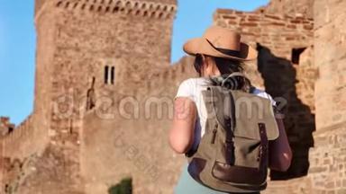 背包客旅游活动妇女攀登中世纪城堡墙欣赏景观后景