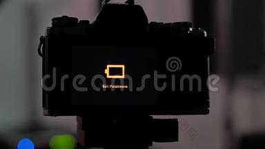 照片工作室的三脚架上的相机显示它已经耗尽了电池的能量。 相机关了。