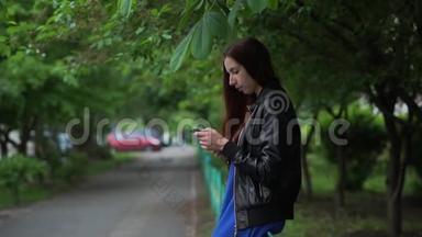 斯洛莫春天坐在户外用手机上网的漂亮女孩