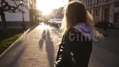 棕色，长头发的女孩，穿着黑色皮夹克和黑色太阳镜，走着，甚至穿过满是城市街道。