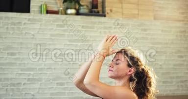 在瑜伽工作室的特写中，漂亮的女士祈祷瑜伽冥想姿势，她感到放松，心情和气氛都很好