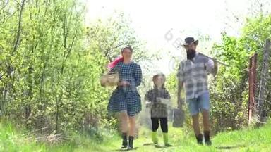 乡村生活-农场的春天。 爸爸妈妈和儿子一起玩。 家庭生态农场。 父母教孩子。 地球
