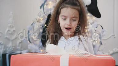 特写新年视频：一个孩子在礼物盒后面搓手，思考如何打开
