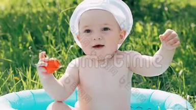 情绪激动的小男孩，孩子沐浴在一个充气的游泳池里，开怀<strong>大笑</strong>