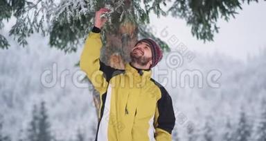 一位热情的游客在山上的一棵雪树<strong>下</strong>玩树枝，享受这一刻