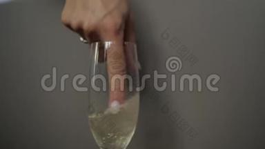 那个女人用手指在杯子里搅动<strong>起泡酒</strong>。