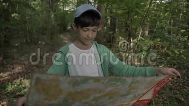 有趣的男孩在森林里看地图，地标，户外