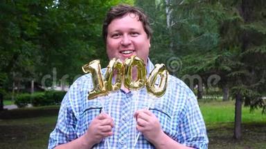 大个子拿着金色气球，在户外做1000个数字。 <strong>十周年庆典</strong>晚会