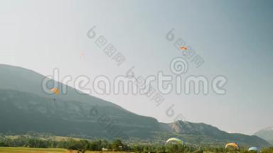 一群活跃的人在滑翔伞上飞行，背景是蓝天和山脉。 Paraplane跑道。 在A中飞行滑翔伞