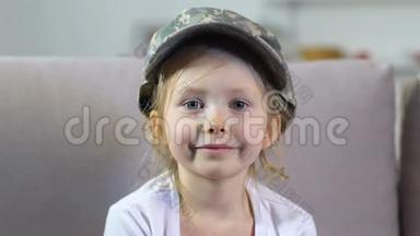 可爱的女孩戴着军帽看着镜头特写，爱国民族，和平