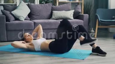 肌肉发达的年轻女士在家里练习瑜伽垫上的腹部肌肉