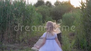 活泼开朗的小女孩穿着白色的衣服，在绿油油的<strong>芦苇丛</strong>中沿着独木桥跑