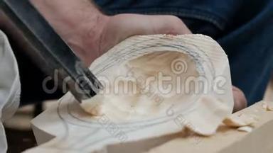 用木头做勺子或铲子。 特写镜头。 男手用木工工具空心出一个木制品.. 手工制作