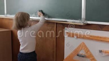 女孩在教室里用毛巾<strong>擦黑板</strong>。 教育进程