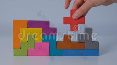 特写慢动作.. 手持一块木块拼图.. 木立方体堆叠。 复杂而聪明的逻辑概念