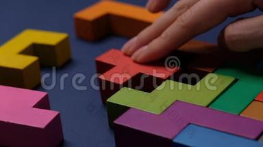 特写.慢动作.. 手持一块木块拼图.. 木材立方体堆叠。 复杂而聪明的逻辑概念