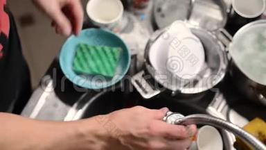 一人洗碗，特写.. 在框架内，双手擦盘子，节约用水不白倒.