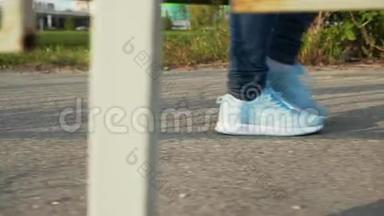 穿蓝色运动鞋和牛仔裤的儿童在户外散步