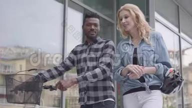 肖像英俊自信的非裔美国人穿着休闲服装，骑着自行车靠近城市的商店橱窗