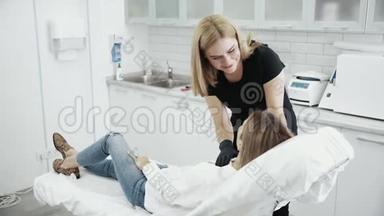 美容师在手术前检查病人`面部。 年轻女孩接待美容师