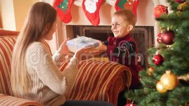 微笑的小男孩给他妈妈圣诞礼物的视频。 家庭捐赠和接受新年礼物