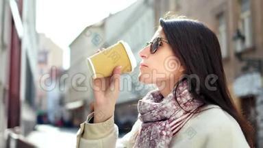 时尚的时髦微笑女人喝着咖啡纸杯欣赏<strong>欧洲建筑</strong>