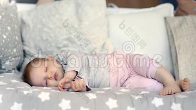 可爱的无忧无虑的小宝宝，睡在柔软的枕头周围，闭着眼睛镜头躺着