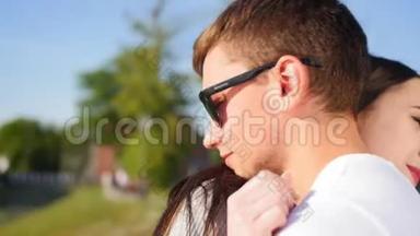 年轻的微笑夫妇拥抱在阳光公园，糖果花时期，<strong>真情</strong>。 一起快乐。 近距离射击。