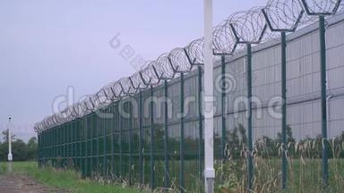 带刺铁丝网的<strong>监狱</strong>栅栏，又长又高的绿色栅栏