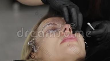 美容院的<strong>专业美容师</strong>用特殊的电影闭上客户的眼睛。