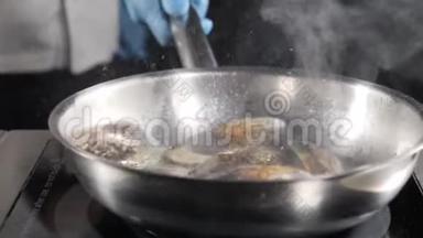 精彩慢动作美食视频.. 厨师烹饪或在煎锅中品尝海鲜。 溅出来的油。 高清高清