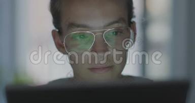 高质量的4k12位镜头。 年轻的办公室工作人员在笔记本电脑上打眼镜，找出问题。 深夜