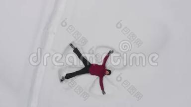 年轻女子在雪地里做一个<strong>雪天</strong>使，无人驾驶的俯视图。