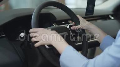 女人用手指靠近方向盘。 现代女孩在<strong>车展</strong>上看汽车。 概念