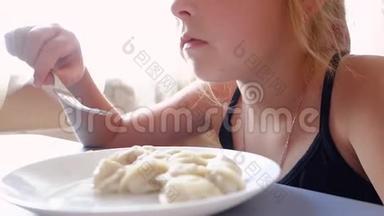 十几岁的女孩在窗户的背景上<strong>吃饺子</strong>。
